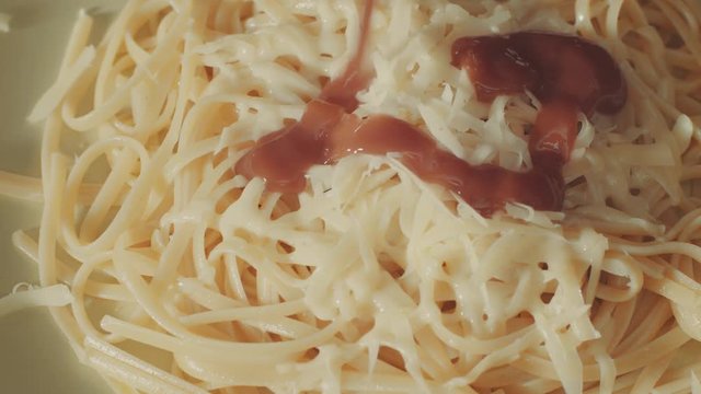 Hot spaghetti with cheese on a plate adding tomato sause