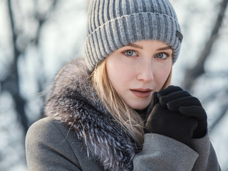 Portrait of young woman at sunny winter day.