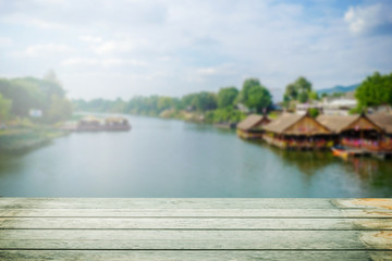 Fototapeta premium Wood pier or an old wooden table with blur image of lake and sunset sky in background
