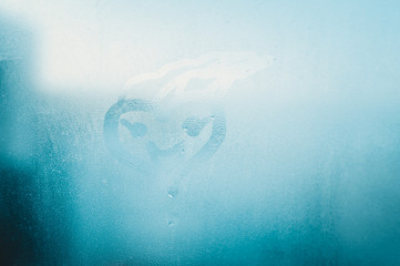 Love heart drawing on fogged glass surface background. Emotional sensual feeling