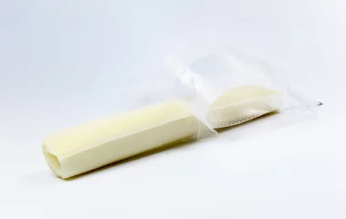 Gordijnen Unwrapped mozzarella string cheese on a light colored background.   © ImagePixel