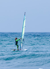 Girl exercising in windsurfing in the Mediterranean sea
