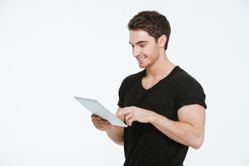 Young happy man using tablet computer.
