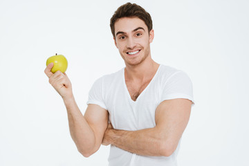 Cheerful man looking at camera and holding apple.