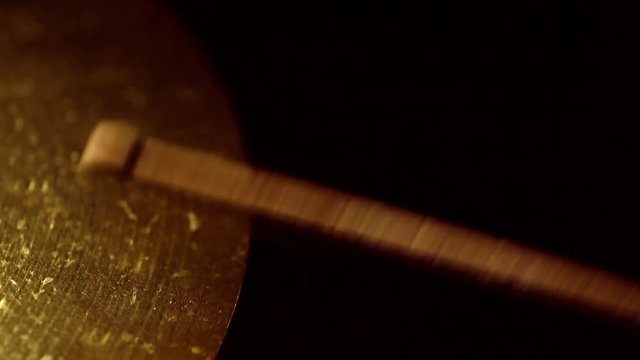 Close up panning footage of two drum sticks hitting a cymbal.