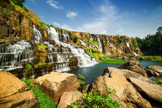 Fototapeta Niesamowity widok na naturalny kaskadowy wodospad z krystaliczną wodą