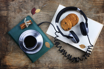 audiobook headphones and book on wooden table