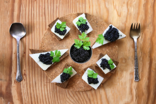 snack black caviar on a wooden background