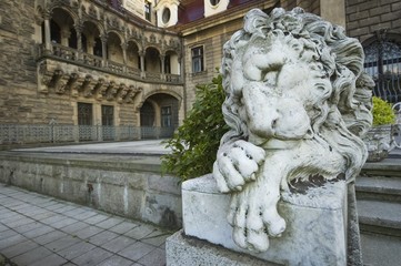 Fototapeta na wymiar Stone statue of lion in entrance portal of the old castle in Moszna, near Opole, Silesia, Poland
