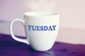 white cup with the word Tuesday on it