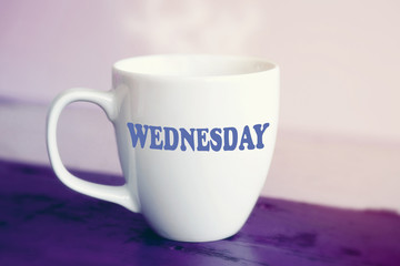 white cup with the word Wednesday on it