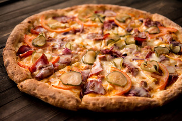delicious pizza on thin crust with chicken, cheese, pickles and peppers