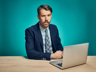 Sad Young Man Working On Laptop At Desk