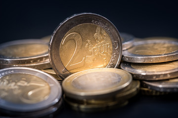 lot of euro coins with reflection on black table.