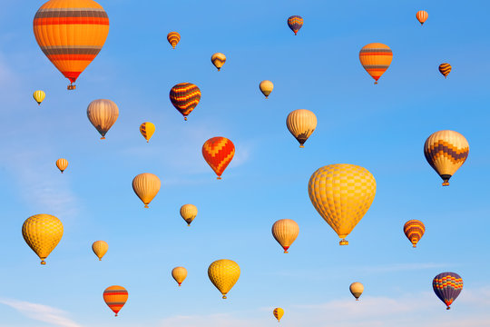 Vibrant colorful air balloons in blue sky.