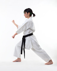 Young black belt fighter training Karate. Isolated woman portrait on white background © gg333