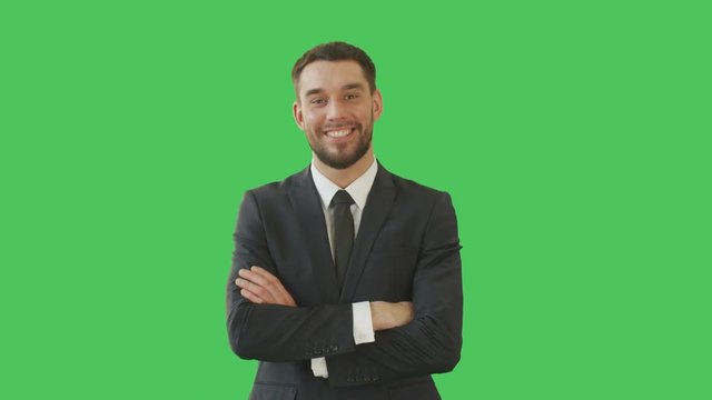 Medium Shot of a Handsome Businessman in a Tailored Suit Crossing Arms on His Chest and Smiling Warmly. Shot on a Green Screen Background.  Shot on RED Cinema Camera 4K (UHD). 