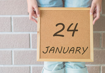 Closeup cork board in hand of woman in front of her legs