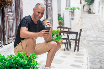 Talking with friend. Full length of handsome young man with smartphone