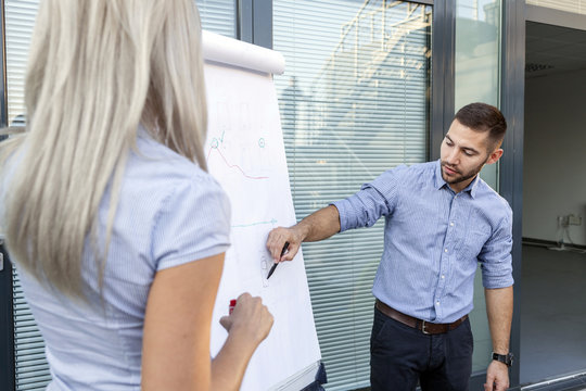 Business people analyzing together data on flipchart