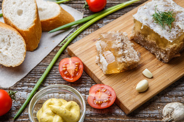 Homemade jelly meat with mustard, bread, tomatoes and garlic on the table. Holodets