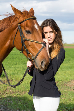 Beautiful young girl with her horse dressing uniform competition: outdoors portrait on sunny day
