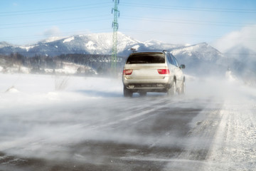 Fototapeta na wymiar Car on road in a snow blizzard
