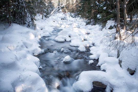 Long exposure of river in winter forest at Jalovecka valley, Slovakia