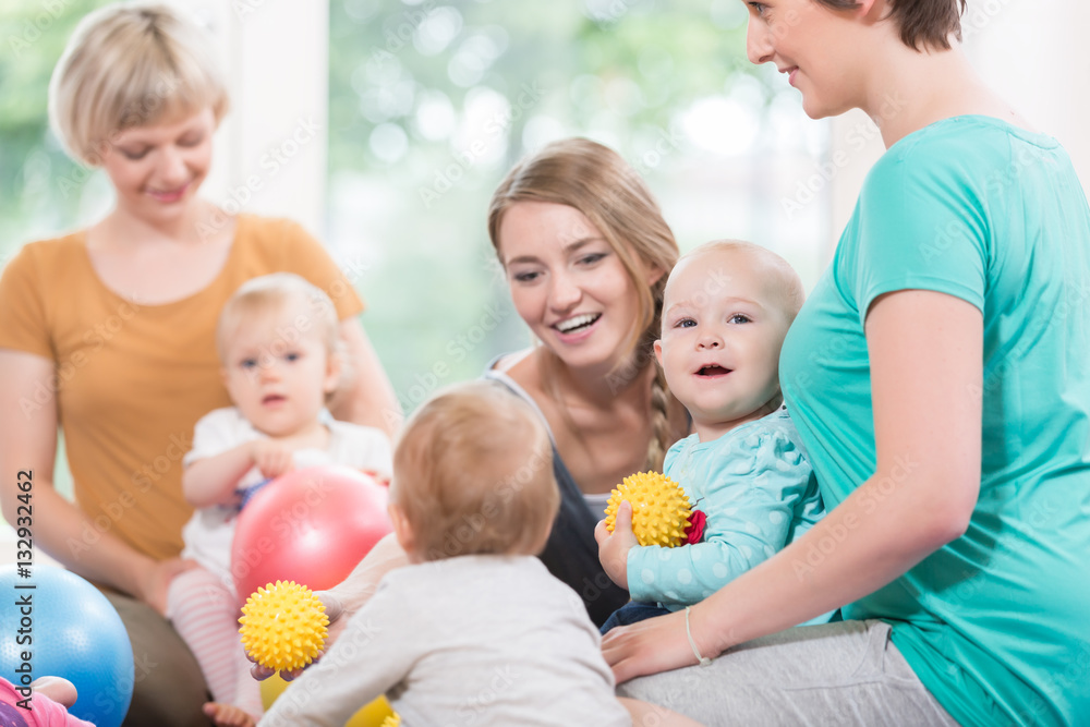 Wall mural junge mütter und ihre kinder spielen gemeinsam im mutter-kind-kurs