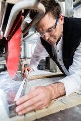 Handwerker bereitet Steinplatte für Zuschnitt auf Diamantsäge vor 