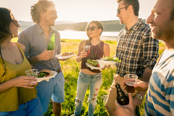 Group of friends standing in circle on barbecue party