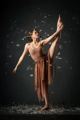 Foto op Plexiglas girl dancing barefoot with feathers. ballet. grey background     © olgamazina