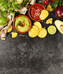 Fototapeta na wymiar Green Homemade Guacamole with Tortilla Chips and Salsa