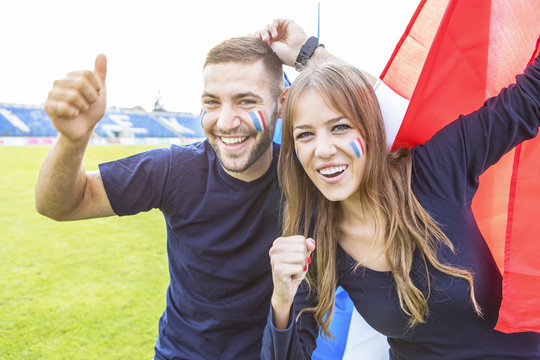Young couple with face paint and French flag