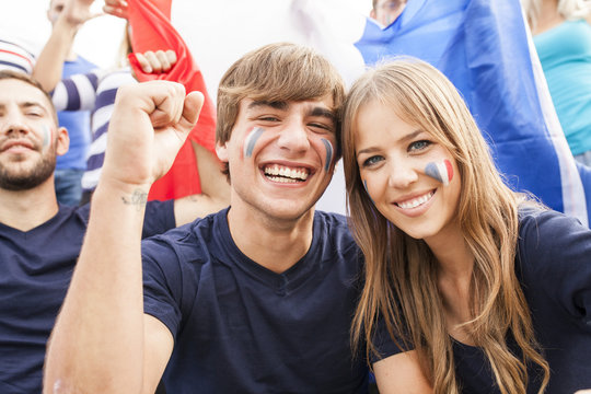 Group of soccer fans celebrating with French flag