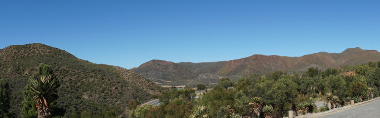 Fototapeta na wymiar Panorama in der Kleinen Karoo/Landschaft in der Halbwüste Kleine Karoo in der Republik Südafrika, Berge, karge Vegetation und blauer Himmel, Panorama