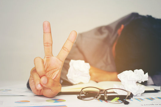 Businessman sleeping at his desk working over a laptop after he work all day all night, Tried overworked, Keep fighting in business concept.