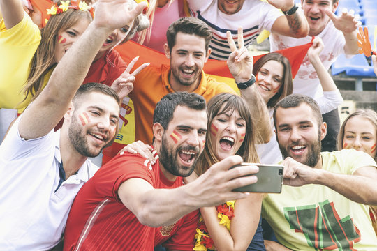 Group of soccer fans taking a selfie in stadium