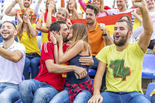 Young couple in stadium kissing