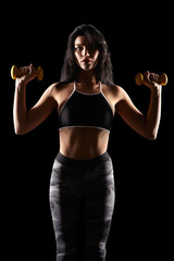 Portrait of a young brunette sporty fitness woman with dumbbell