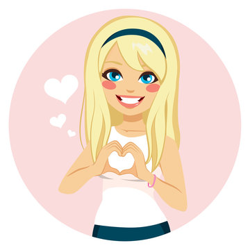 Beautiful blonde girl making heart shape with hands on Saint Valentine day