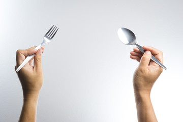 Man hand holding a silver fork and spoon