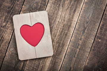 Heart shaped wooden frame on wooden boards