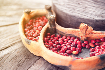 Close up red seeds on wooden table.