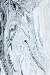 Fototapeta premium White and black paint mixing together creating shapes.