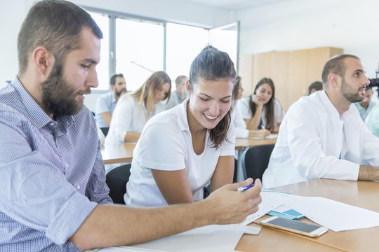 Students in training class looking at smartphone