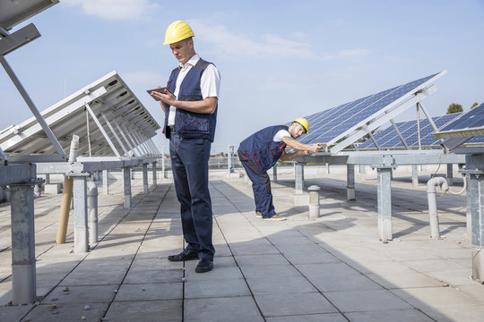 Construction workers checking solar panel structures