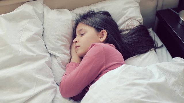 Little girl sleeps. Girl is sleeping. Little girl dressed in pajamas asleep in bed in the children's room.