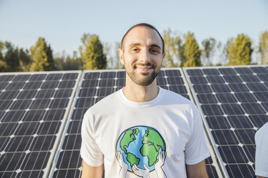 Portrait of teenage environmentalist in front of solar panels