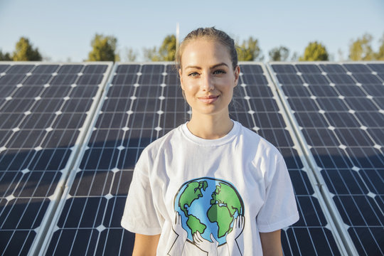 Portrait of teenage environmentalist in front of solar panels